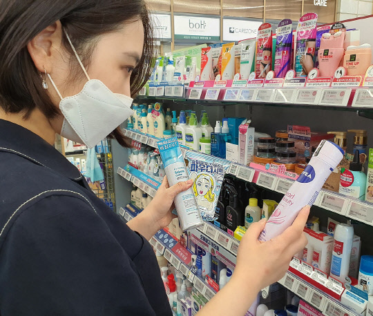 뷰티업계에서 '습기 제거' 제품들이 인기를 끌고 있는 가운데 18일 한 여성고객이 화장품을 고르고 있다.    CJ올리브영 제공